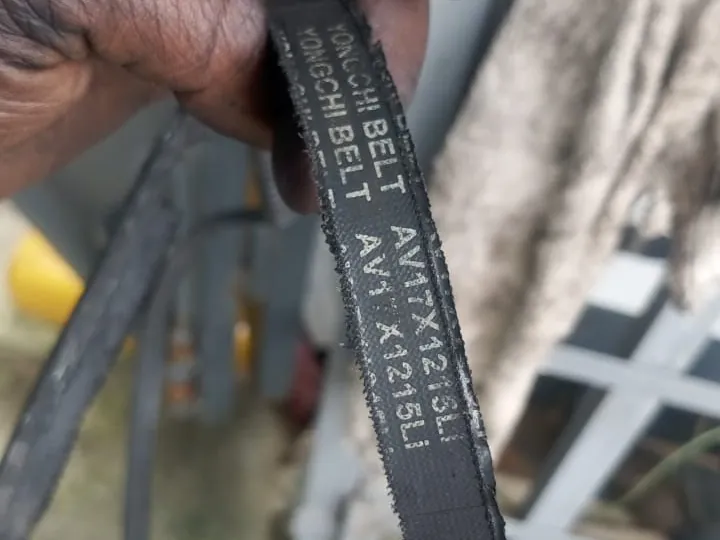 Courroie trapézoïdale usée tenue en main