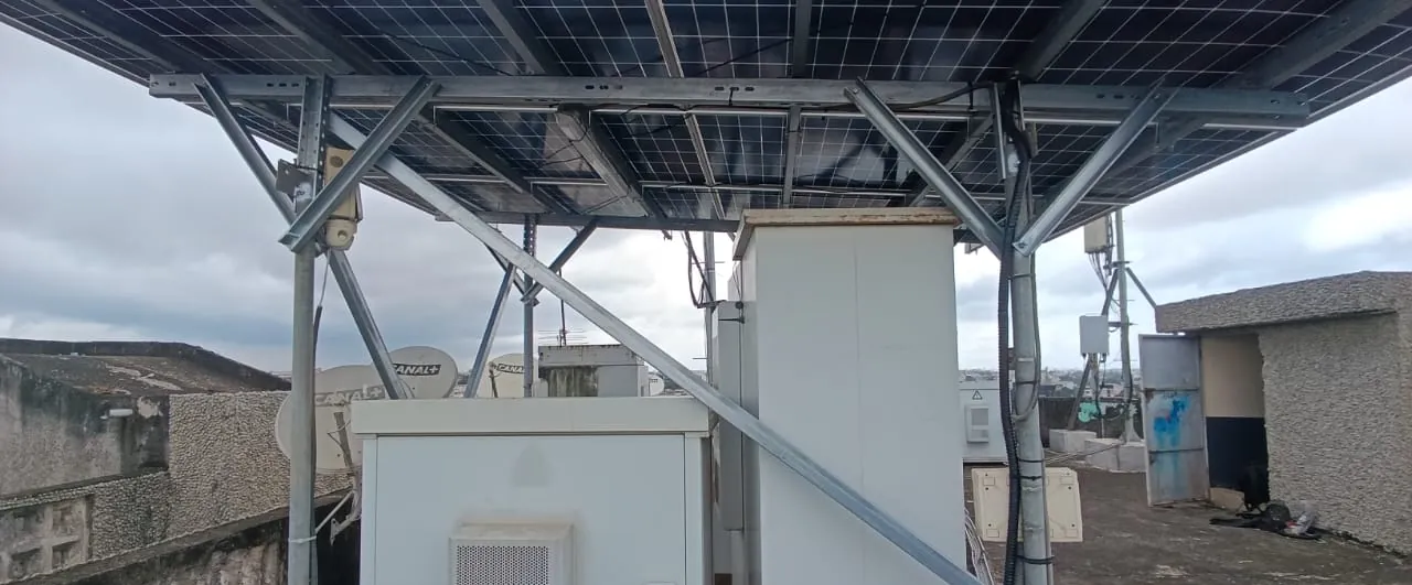 Armoires techniques abritées sous un auvent de panneaux solaires, contreventement en acier
