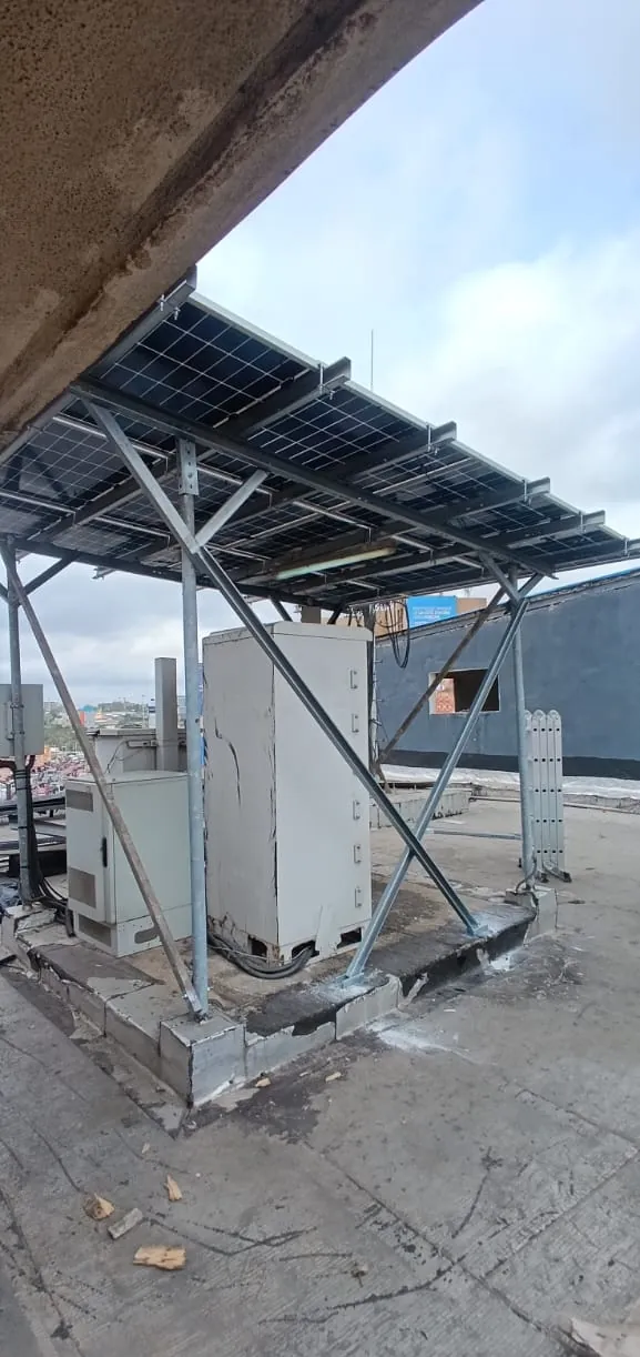 Auvent solaire en acier galvanisé fixé sur muret béton, au-dessus d'une armoire télécom
