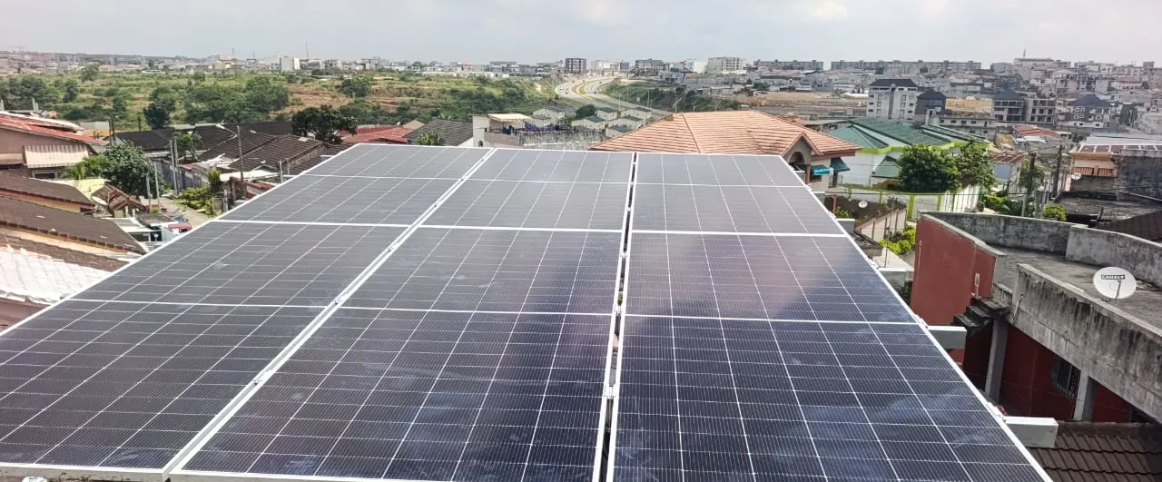 Champ de panneaux solaires monocristallins posé en toiture, vue sur la ville