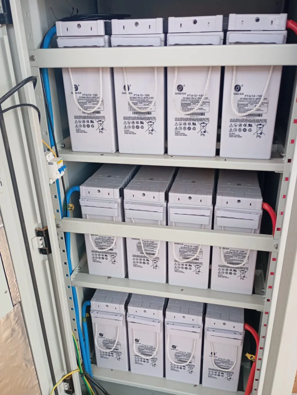 Armoire de batteries de secours : douze batteries 12 V 150 Ah au plomb étanche, en trois rangées de quatre