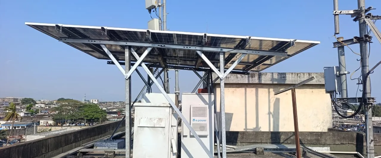 Armoires d'énergie et de télécommunications en toiture, sous une structure de panneaux solaires